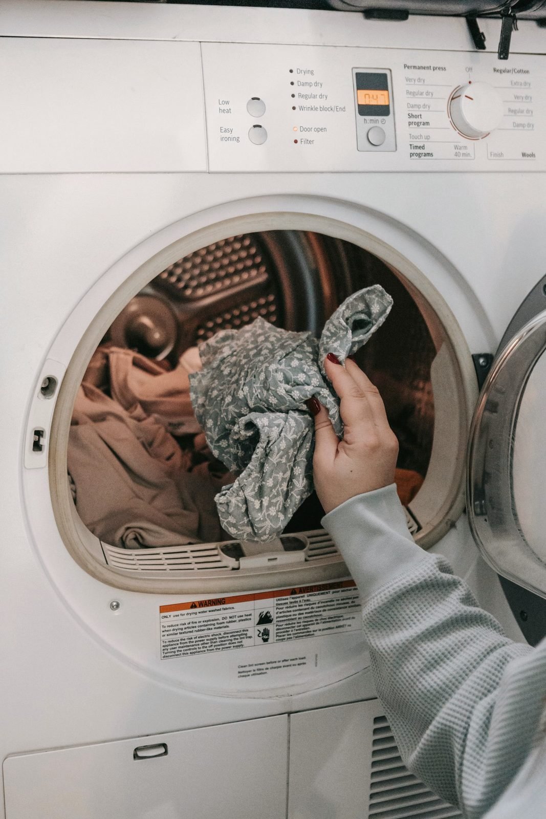 Laundry being pulled from a front-load dryer